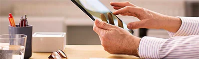 A close-up of a legal sector worker using an electronic tablet at his desk.