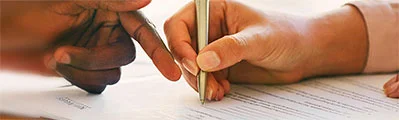 a close-up of someone signing a document