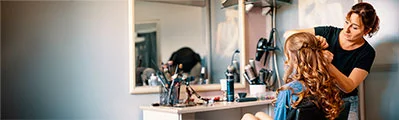 A stylist is putting the finishing touches to a customer's hairstyle